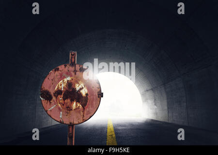 old grunge stop sign in front of darken tunnel with fog and light at the end of tunnel Stock Photo