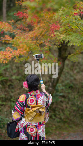 JAPANESE KIMONO CLAD GIRL TAKING SELFIE IN PARK, BYODOIN TEMPLE (1053)      UJI,  JAPAN Stock Photo