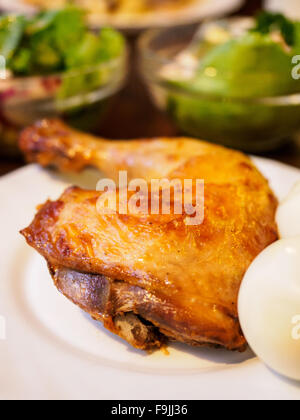 fried chicken thigh on a white plate with boiled egg in the background Salad greens Stock Photo