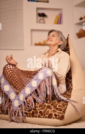 Senior woman doing meditation at home Stock Photo