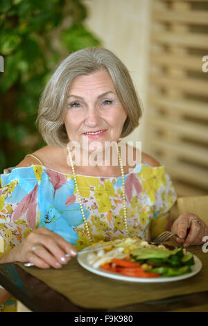 Senior woman eating breakfast Stock Photo
