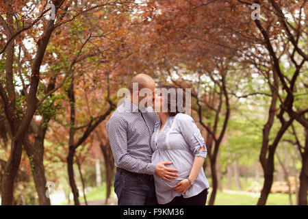 Happy and young pregnant couple embracing in nature Stock Photo