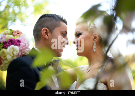 Happy bridal couple on wedding day embracing in nature Stock Photo