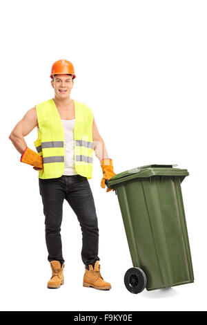 Full length portrait of a young male waste collector posing next to a green trash can isolated on white background Stock Photo