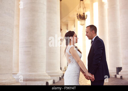Beautiful bridal couple embracing near columns Stock Photo