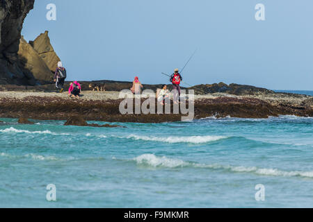 Anglers fishing from rocks on Tip of Borneo beach Sabah East Malaysia Island of Borneo Stock Photo