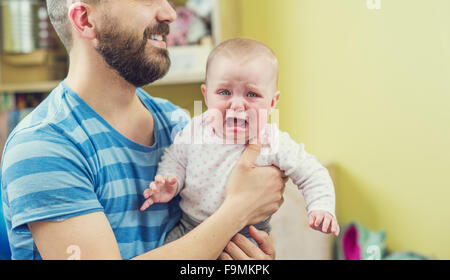 Young hipster father hugging his cute little daughters Stock Photo