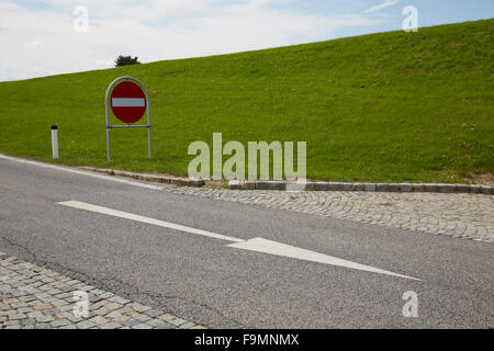 One way road with No Entry road sign and a painted directional arrow. Stock Photo