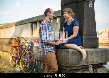 Young couple with bicycles sitting on the promenade. Stock Photo