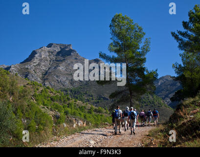 Hikers below La Sombra del Lobo or Shadow of the Wolf Mountain in the Sierra de Almijara, Near Nerja, Malaga Province, Andalucia, Spain Stock Photo