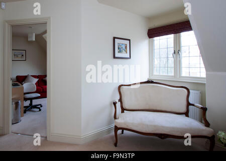 A landing with a chair seat by the window and a doorway Stock Photo