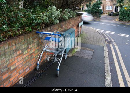 An abandoned supermarket trolley near a busy suburban road in south London. Stock Photo