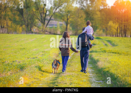 Happy family walking with dog Stock Photo