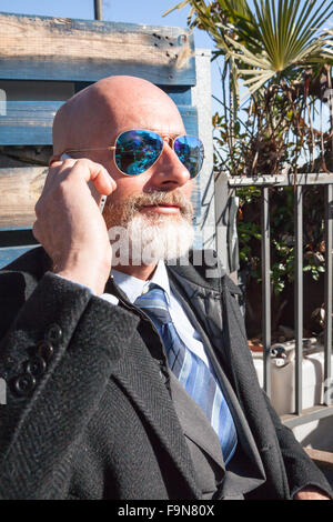 Middle-aged man , handsome and elegant working outside the office in a relaxed and sunny atmosphere Stock Photo