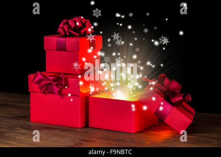 festive opened boxes with bow and snowflakes light on wooden background is isolated, closeup Stock Photo