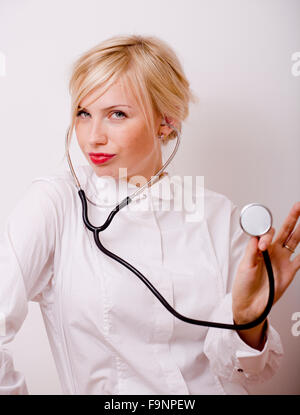 funny doctor with stethoscope, smiling blond woman medical equipment Stock Photo