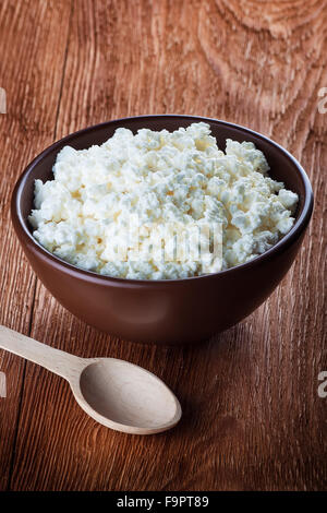 cottage cheese in a clay bowl on wooden table Stock Photo