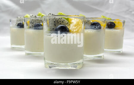 yogurt penna cotta with various fruits topping in glassware on soft tone background Stock Photo