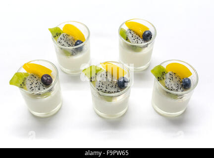 yogurt penna cotta with various fruits topping in glassware on soft tone background Stock Photo