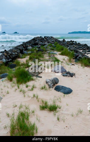 Narrow Path Filled With Big Stones in front of the ocean at a beach Stock Photo