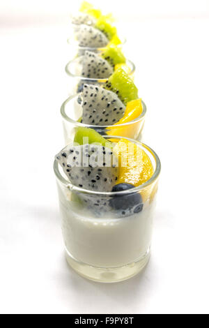 yogurt penna cotta with various fruits topping in glassware on soft tone background Stock Photo