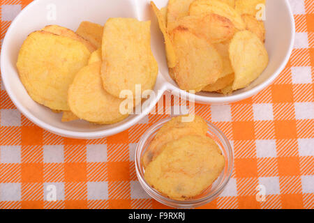 chips and peeled potato on a white plate Stock Photo