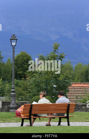 Couple reading on a bench. Stock Photo