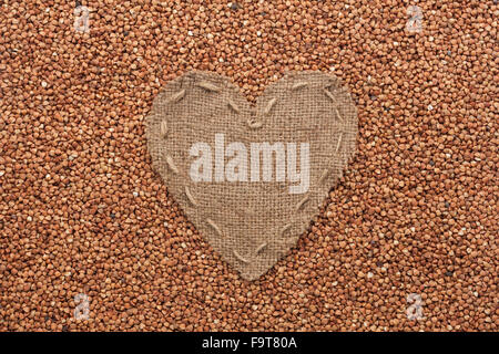Frame in the shape of heart made of burlap with buckwheat, with space for your text Stock Photo