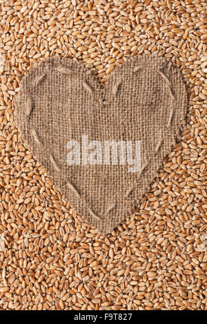 Frame in the shape of heart made of burlap with wheat, with space for your text Stock Photo