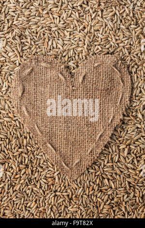 Frame in the shape of heart made of burlap with rye, with space for your text Stock Photo