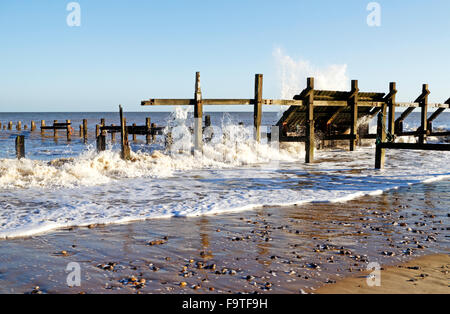 Old wooden coastal sea defences buffeted by waves at Happisburgh, Norfolk, England, United Kingdom. Stock Photo