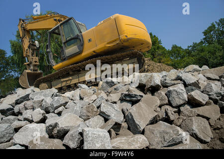 Backhoe On Large Pile Of Rocks Stock Photo