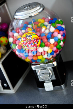 Colourful traditional round bubble gum in coin operated candy dispensing machine in shopping centre