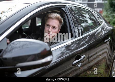 Young man in car looking out of window Stock Photo