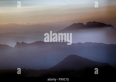 sunset on hilltops in the mist around Titan Mount in the Repubblic of San Marino Stock Photo