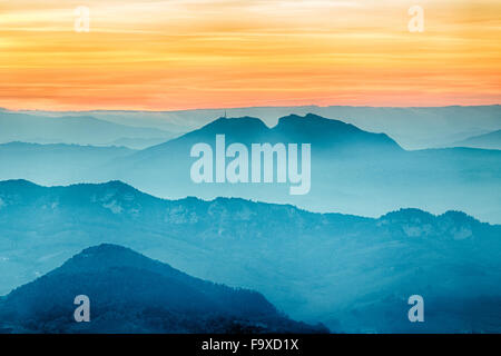 sunset on hilltops in the mist around Titan Mount in the Repubblic of San Marino Stock Photo