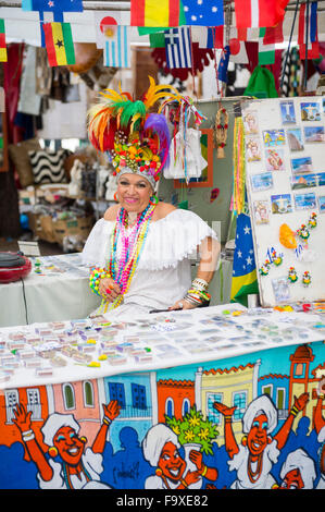 RIO DE JANEIRO, BRAZIL - OCTOBER 25, 2015: Brazilian street vendor dressed in flamboyant costume sells goods from a stall. Stock Photo