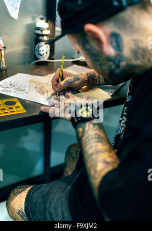 Tattoo artist designing motifs Stock Photo