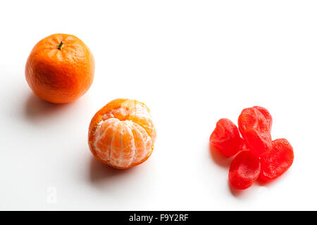Peeled tangerine or mandarin fruit and candied orange fruit isolated on white background cutout