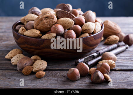 Variety of nuts with shells in a brown bowl Stock Photo