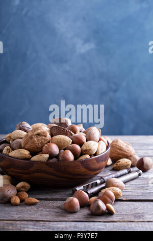 Variety of nuts with shells in a brown bowl Stock Photo
