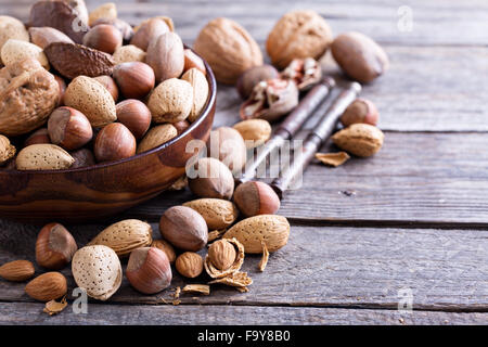 Variety of nuts with shells in a brown bowl Stock Photo