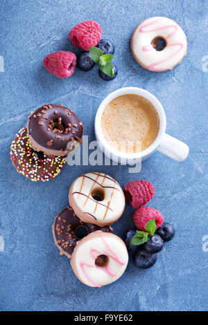 Small glazed mini donuts with fresh raspberries and blueberries Stock Photo