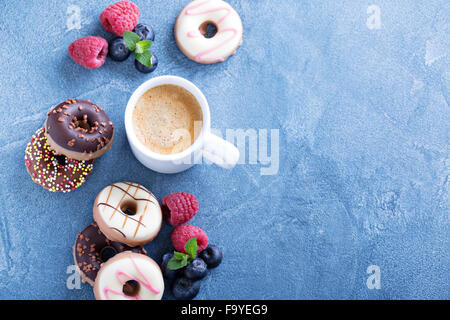 Small glazed mini donuts with fresh raspberries and blueberries Stock Photo