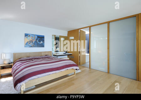 The master bedroom of a house on the cliffs on the sea. Glass panels. Light airy space. Stock Photo