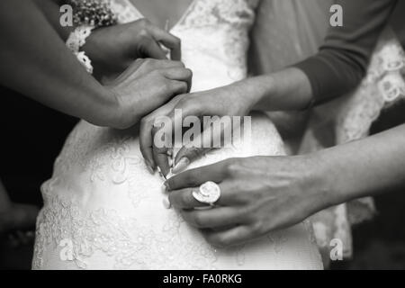 Bride putting on her dress Stock Photo