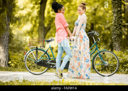 Young women posing by the bicycle Stock Photo