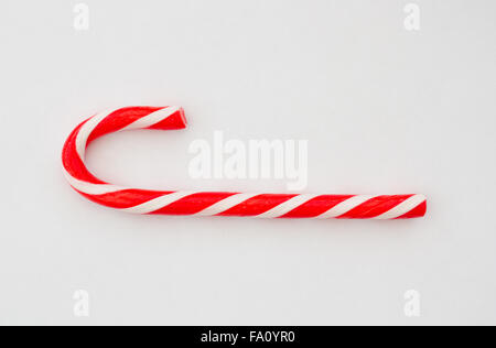 A red and white striped, Christmas candy cane on a white background. Stock Photo