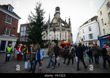 Christmas shoppers pass in front of the Chichester Market Cross whilst they do some last minute shopping on the last Saturday before Christmas day In Chichester, West Sussex, England. Stock Photo