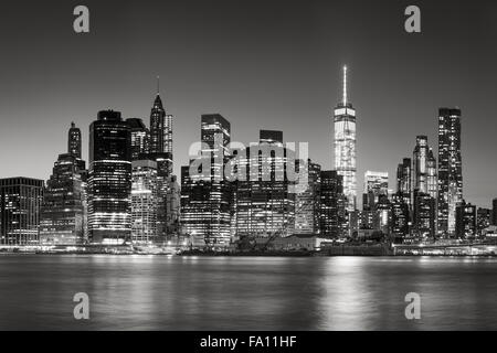 Black & White East River view of Financial District skyscrapers at dusk. Illuminated Lower Manhattan skyline, New York City Stock Photo